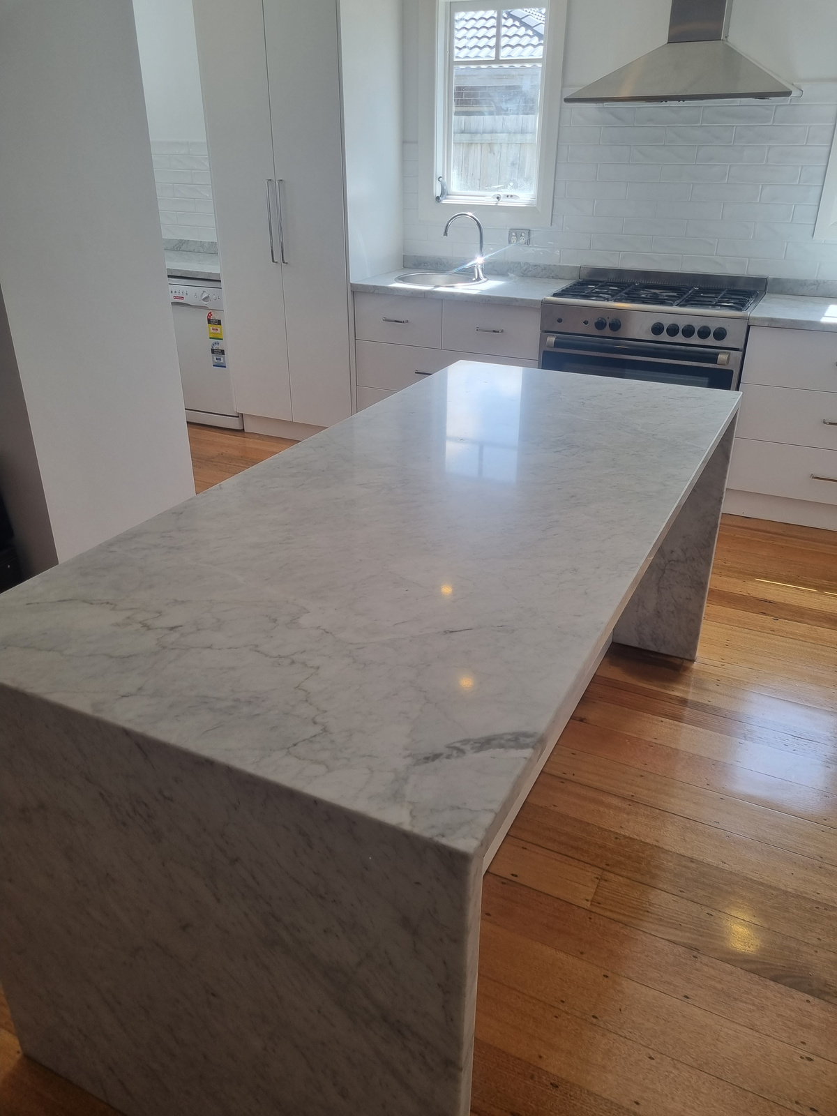 After — Carrara marble kitchen island polished