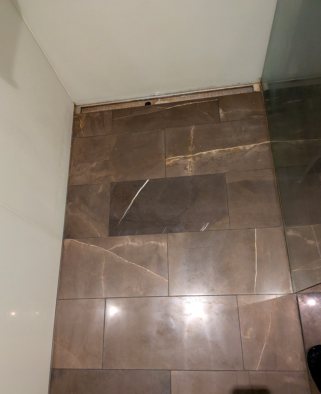After — brown stone shower floor polished